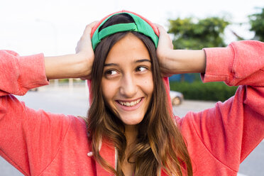 Portrait of smiling girl wearing pink hoodie and basecap - GEMF000421