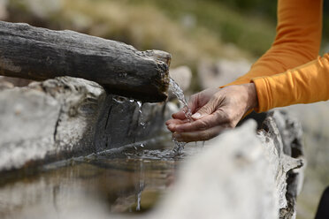 Hände, die Wasser aus einem Brunnen schöpfen - LBF001219