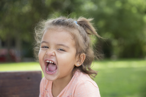 Porträt eines schreienden kleinen Mädchens in einem Park, lizenzfreies Stockfoto