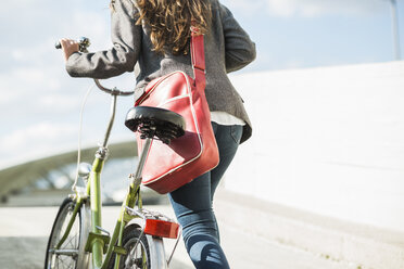 Junge Frau schiebt Fahrrad - UUF005762