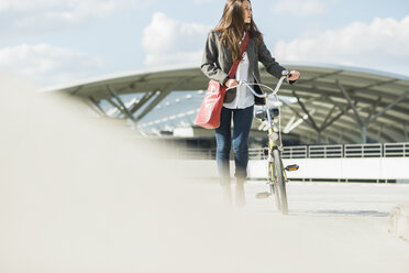 Young woman pushing bicycle - UUF005765