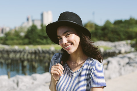 USA, New York City, portrait of smiling young woman wearing black hat stock photo