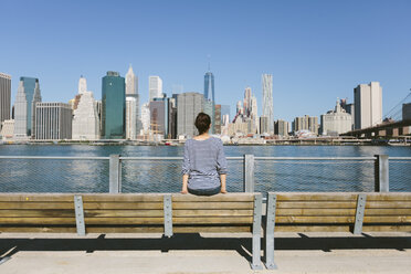 USA, New York City, back view of young woman looking at skyline - GIOF000147