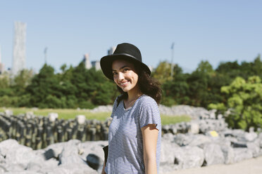 USA, New York City, Porträt einer lächelnden jungen Frau mit schwarzem Hut - GIOF000171