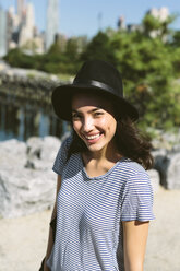 USA, New York City, portrait of smiling young woman wearing black hat - GIOF000174