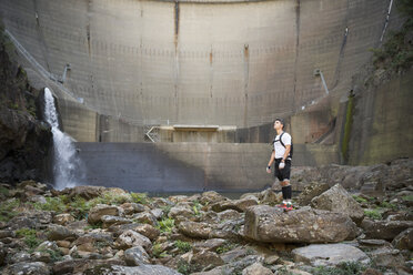 Ultra-Trail-Läufer mit einem Staudamm im Hintergrund - RAEF000519