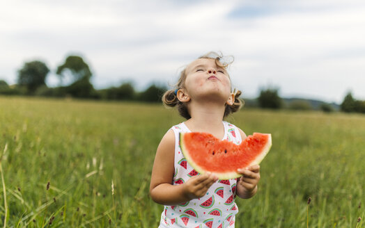 Kleines Mädchen isst Wassermelone auf einer Wiese - MGOF000802