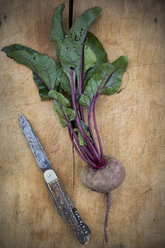 Organic beetroot and pocket knife on wooden board - LVF003929