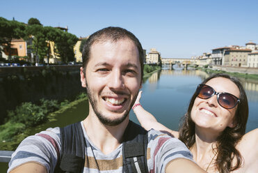 Italien, Florenz, glückliches Paar mit Ponte Vecchio im Hintergrund - GEMF000438