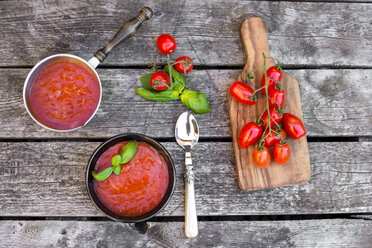Saucepan and bowl of homemade tomato soup on wood - SARF002156