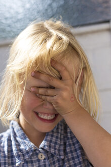 Blondes kleines Mädchen bedeckt die Augen mit ihrer Hand - JFEF000703