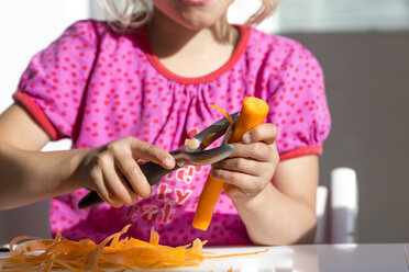 Kleines Mädchen schält eine Karotte, Teilansicht - JFEF000705