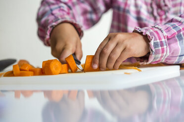 Hands of little girl chopping carrot - JFEF000712