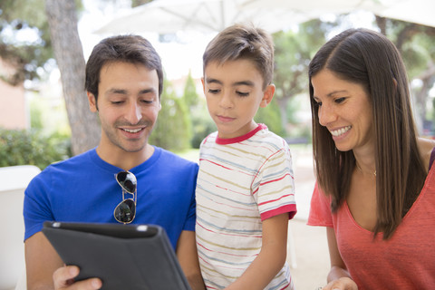 Parents and little son looking at digital tablet stock photo