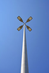 Street lamp with four headlights in front of blue sky - AXF000774