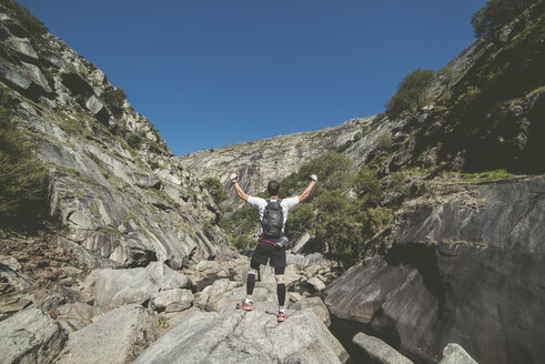 Spanien, Ultra-Trail-Läufer, der mit erhobenen Händen die Landschaft betrachtet und den Sieg feiert - RAEF000523