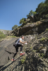 Spanien, Galicien, A Capela, Ultra-Trail-Läufer steigt einen Felshang hinauf - RAEF000525