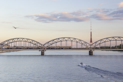 Lettland, Riga, Eisenbahnbrücke und Fernsehturm an der Daugava am Abend - MELF000083