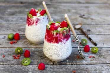 Two glasses of chia pudding with cocos, raspberry sauce and several fruits - SARF002168