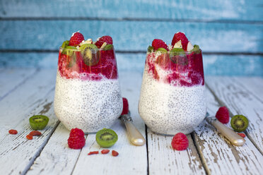 Zwei Gläser Chia-Pudding mit Kokos, Himbeersauce und verschiedenen Früchten - SARF002170