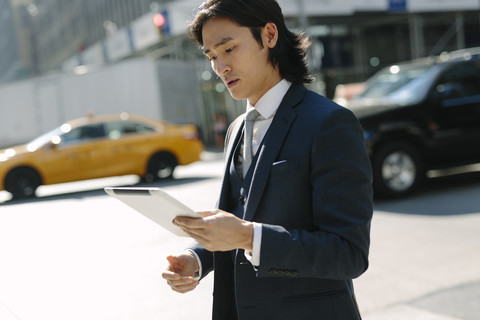 USA, New York City, businessman looking at digital tablet in Manhattan stock photo