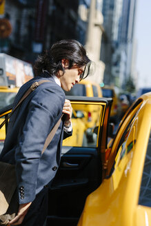 USA, New York City, Geschäftsmann steigt in ein Taxi - GIOF000232