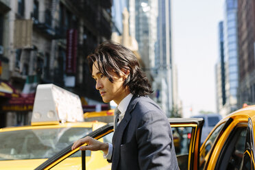 USA, New York City, Geschäftsmann steigt in ein Taxi - GIOF000240