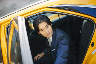 USA, New York City, Porträt eines Geschäftsmannes beim Einsteigen in ein Taxi - GIOF000248