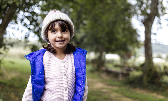 Portrait of smiling little girl wearing woolly hat and waistcoat - MGOF000807