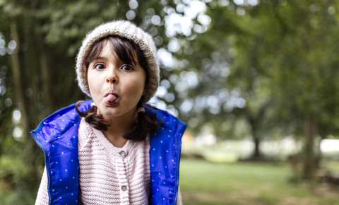 Porträt eines kleinen Mädchens, das seine Zunge herausstreckt, lizenzfreies Stockfoto