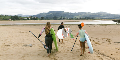 Spanien, Asturien, Villaviciosa, drei Stand Up Paddler auf dem Weg zum Wasser - MGOF000822