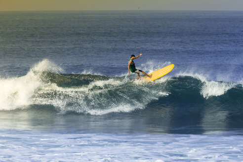 Indonesien, Bali, Mann surft auf einer Welle - KNTF000102