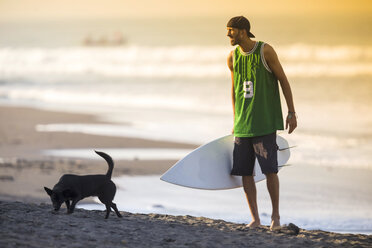 Indonesien, Bali, Surfer und Hund am Strand - KNTF000106