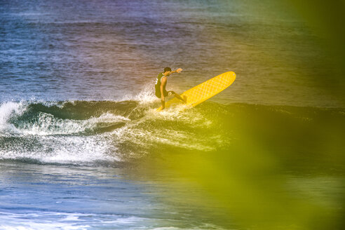 Indonesien, Bali, Mann surft auf einer Welle - KNTF000108