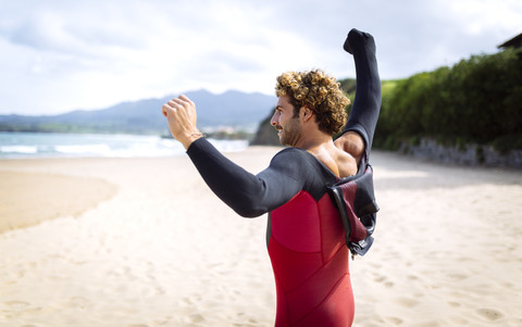 Spanien, Asturien, Colunga, Surfer bei der Vorbereitung auf den Strand, lizenzfreies Stockfoto