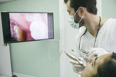 Dentist examining the mouth of a patient with an intraoral camera - ABZF000136