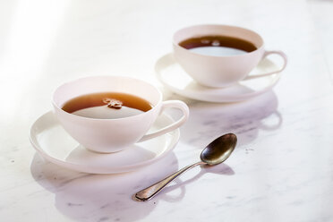 Schwarzer Tee in zwei weißen Porzellantassen - SBDF002277