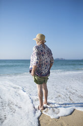 Spanien, Ferrol, Rückenansicht einer am Strand stehenden älteren Frau - RAEF000528