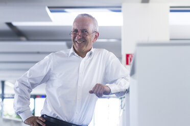 Smiling businessman in open space office - SGF001895