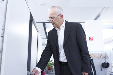 Geschäftsmann am Aktenschrank im Büro - SGF001914