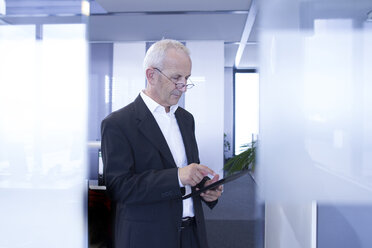 Geschäftsmann im Großraumbüro mit digitalem Tablet - SGF001919