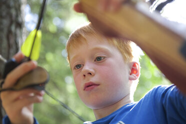 Porträt eines Jungen mit einer Schleife in einem Abenteuerpark - JEDF000250