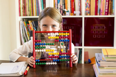 Smiling little girl sitting behind abacus - SARF002177
