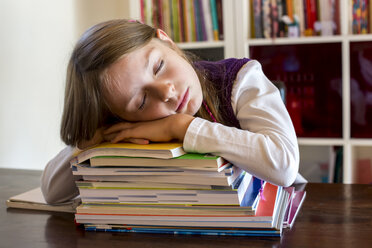Mädchen schläft auf einem Stapel von Schulbüchern - SARF002178