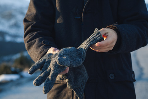 Jugendlicher, der Handschuhe anzieht, lizenzfreies Stockfoto