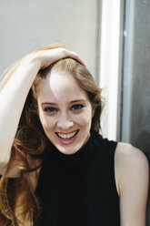 Portrait of smiling young woman with hand on her head - GIOF000258