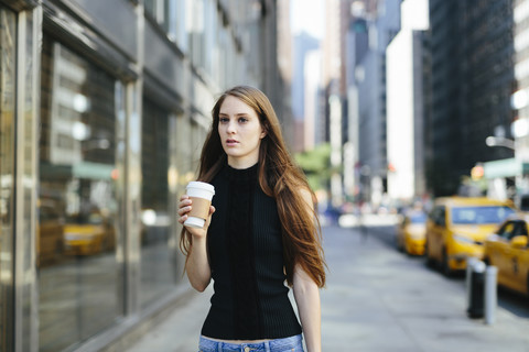 USA, New York City, Porträt einer jungen Frau mit Kaffee zum Mitnehmen, lizenzfreies Stockfoto