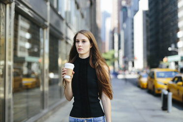 USA, New York City, Porträt einer jungen Frau mit Kaffee zum Mitnehmen - GIOF000265