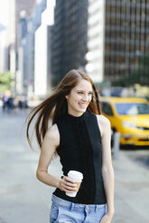 USA, New York City, Porträt einer lachenden jungen Frau mit Kaffee zum Mitnehmen - GIOF000267