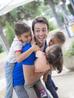 Young man playing with three children - ERLF000060